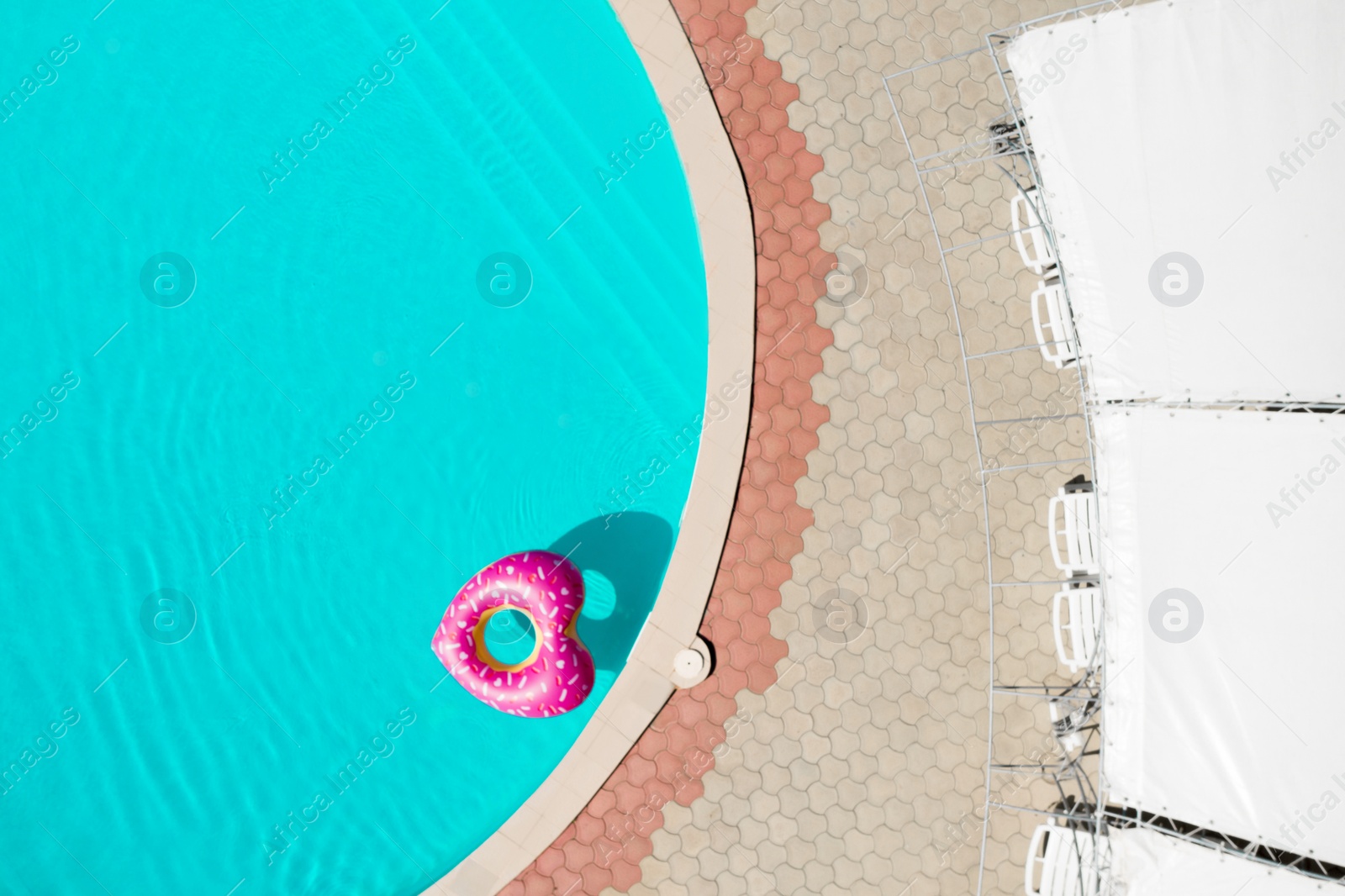 Image of Heart shaped inflatable ring floating in swimming pool, top view. Summer vacation