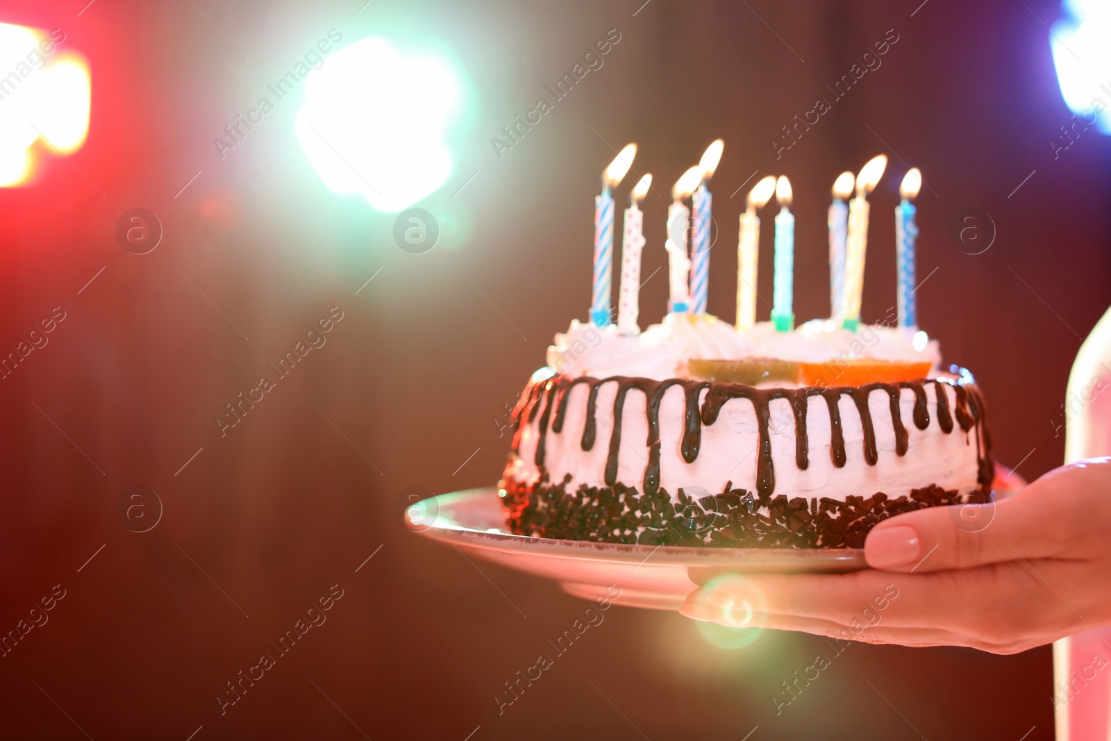Photo of Young woman with birthday cake in nightclub, closeup