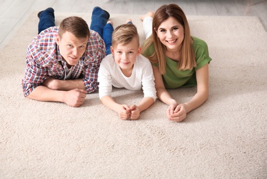 Happy family lying on cozy carpet at home