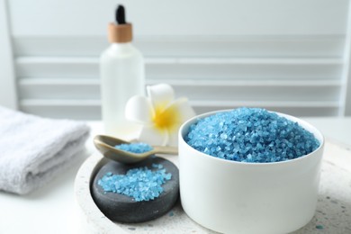 Composition with blue sea salt on white table indoors, closeup