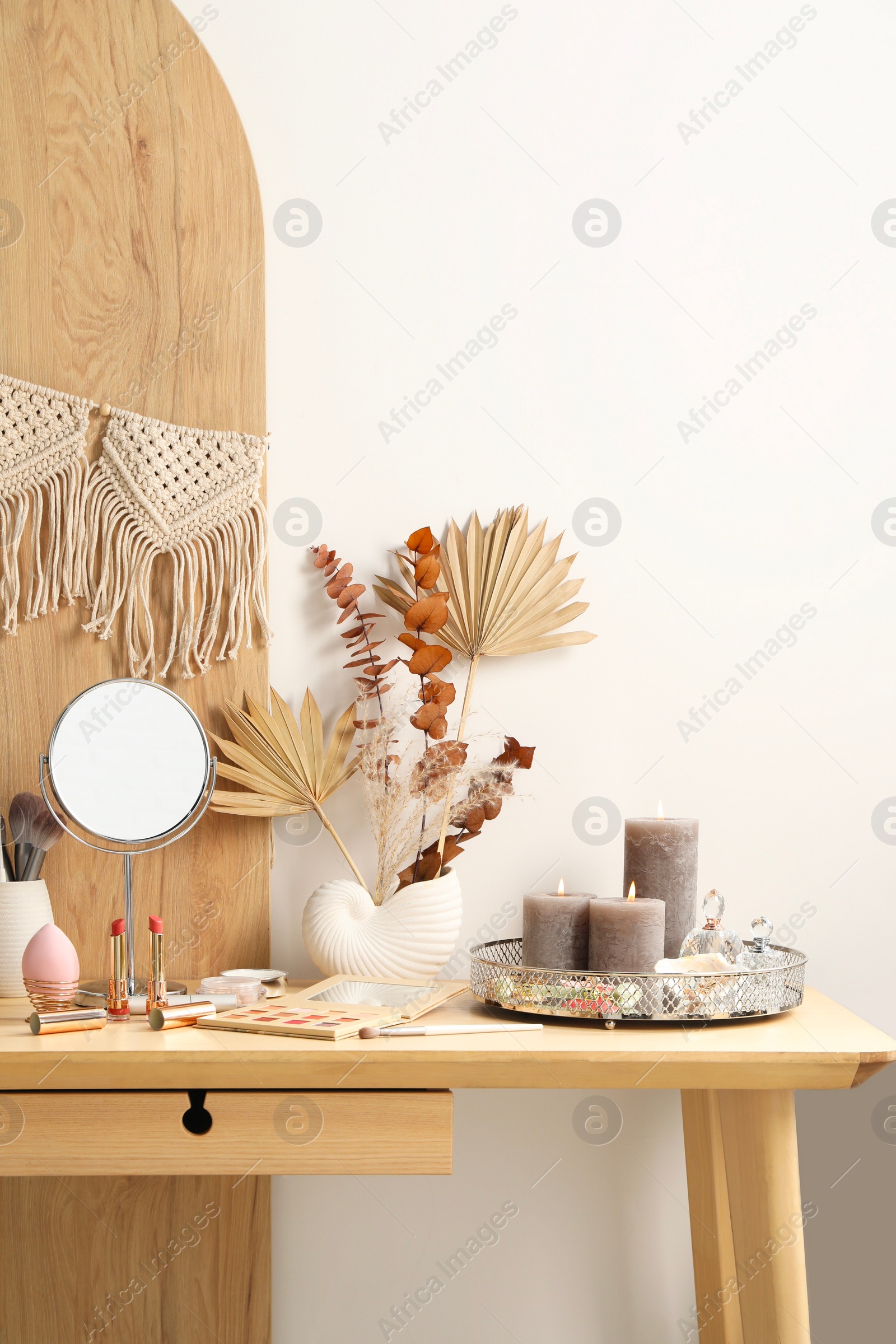 Photo of Dressing table with mirror, makeup products and decor in room