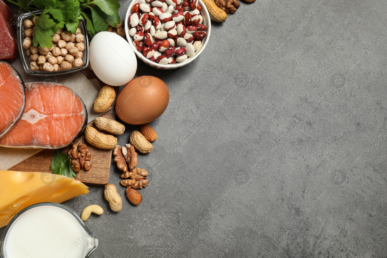 Photo of Products rich in protein on grey table, flat lay. Space for text