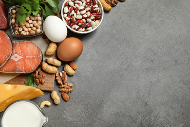 Photo of Products rich in protein on grey table, flat lay. Space for text