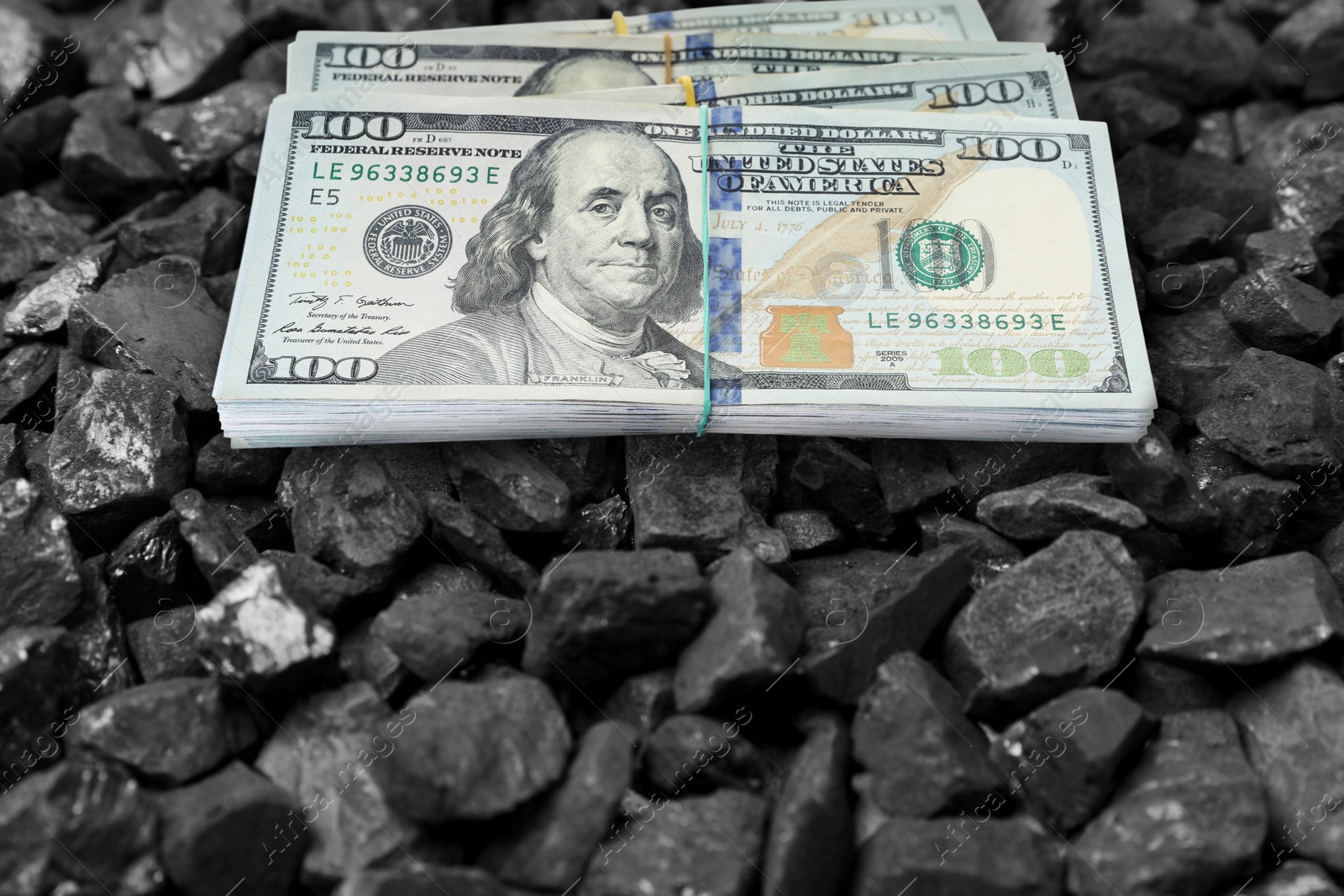 Image of Dollar banknotes on pieces of coal, closeup. Resource price