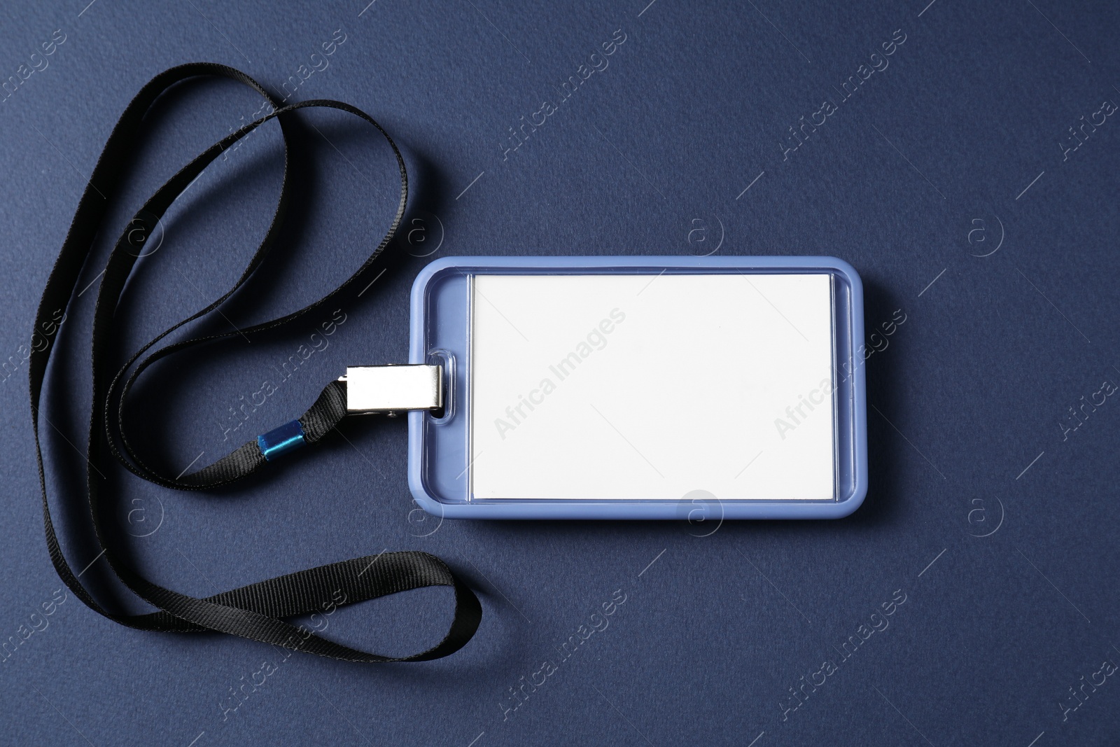 Photo of Blank badge with string on blue background, top view