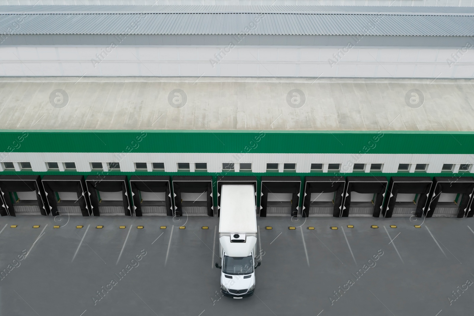 Image of Truck near loading dock of warehouse outdoors, aerial view. Logistics center