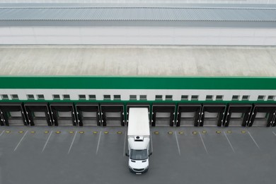 Image of Truck near loading dock of warehouse outdoors, aerial view. Logistics center