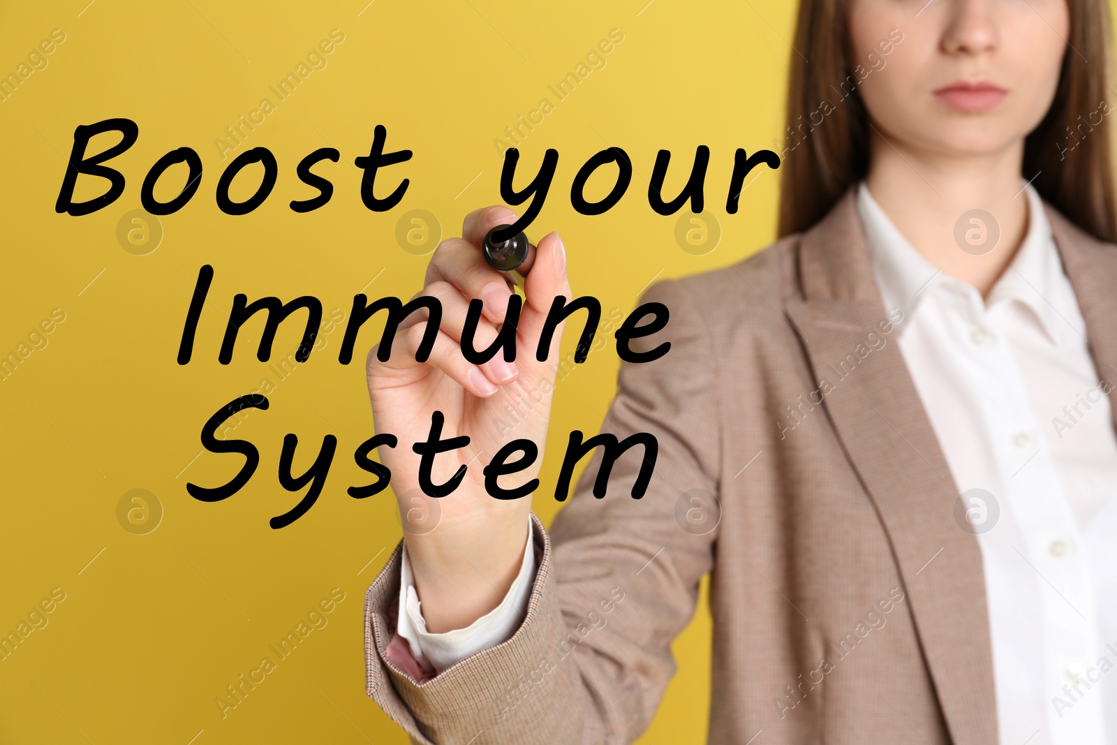 Image of Boost your immune system. Woman writing text on transparent board, closeup