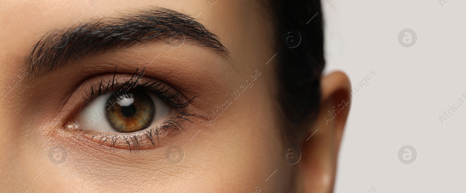 Image of Closeup view of woman with beautiful eyes on white background. Banner design