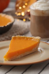 Photo of Fresh homemade pumpkin pie and cup of cocoa with whipped cream on table