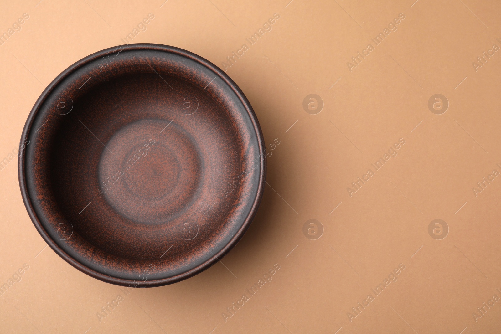 Photo of Ceramic bowl on beige background, top view. Space for text