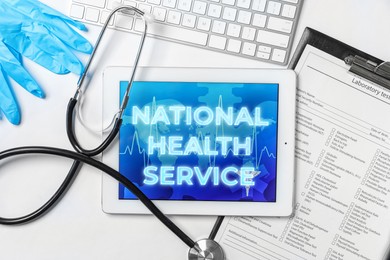 National health service (NHS). Tablet with text, stethoscope, text form, gloves and keyboard on white background, flat lay