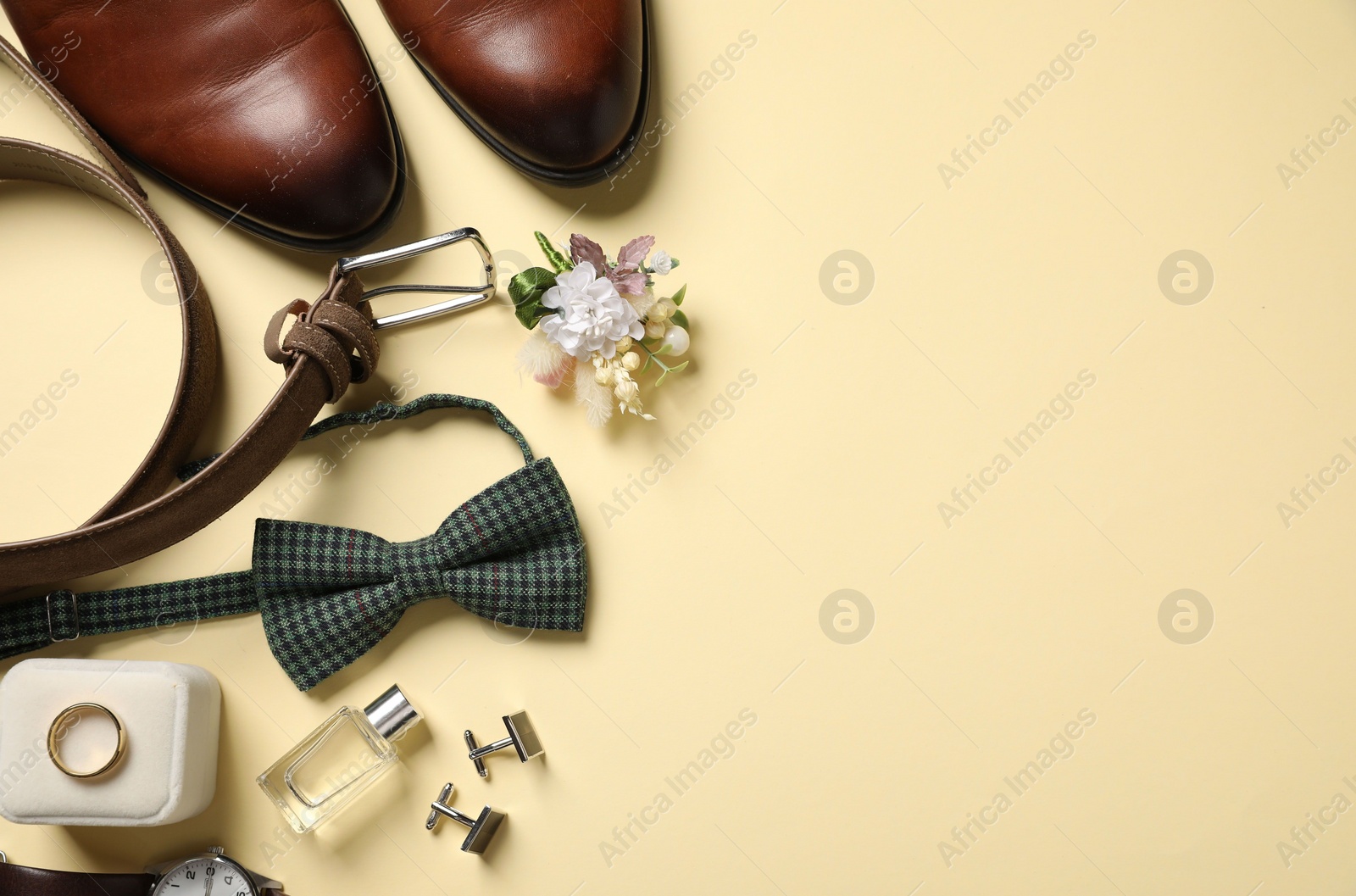 Photo of Wedding stuff. Flat lay composition with stylish boutonniere on yellow background, space for text