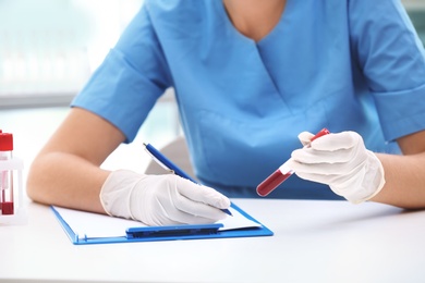 Photo of Scientist working with blood sample at table in laboratory
