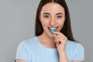 Happy young woman with bubble gum on color background