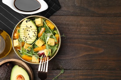 Delicious salad with tofu and vegetables served on wooden table, flat lay. Space for text