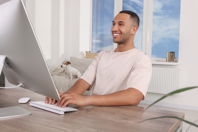 Young man with Jack Russell Terrier working at home office