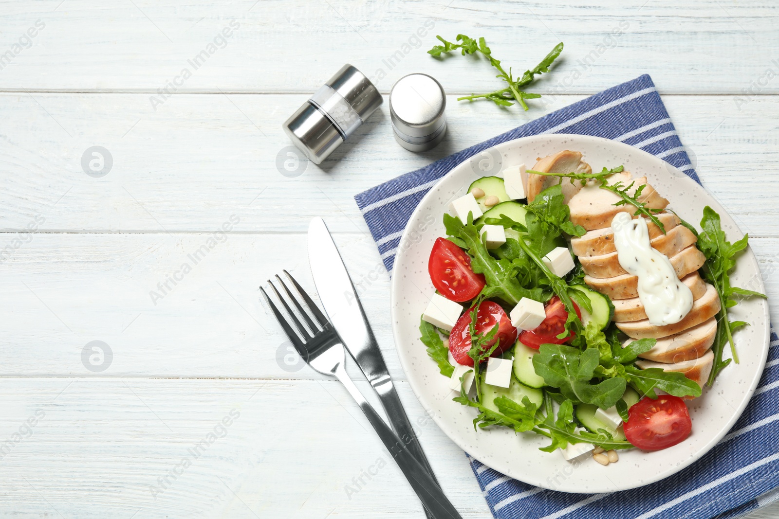 Photo of Delicious salad with chicken, arugula and tomatoes on white wooden table, flat lay. Space for text