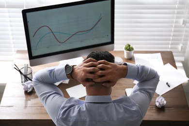 Photo of Businessman stressing out at workplace in office, above view