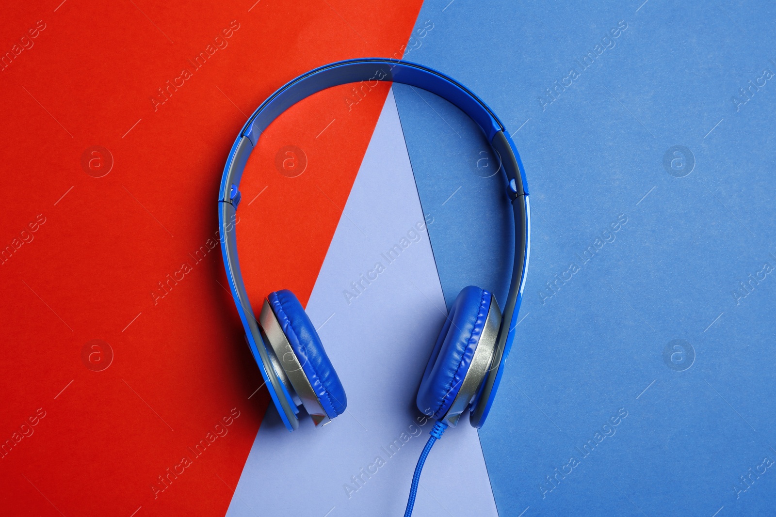 Photo of Stylish headphones on color background, top view