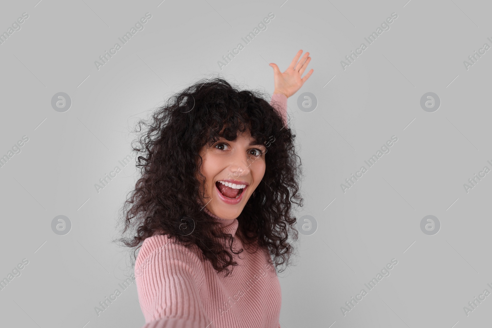 Photo of Beautiful young woman taking selfie on light grey background