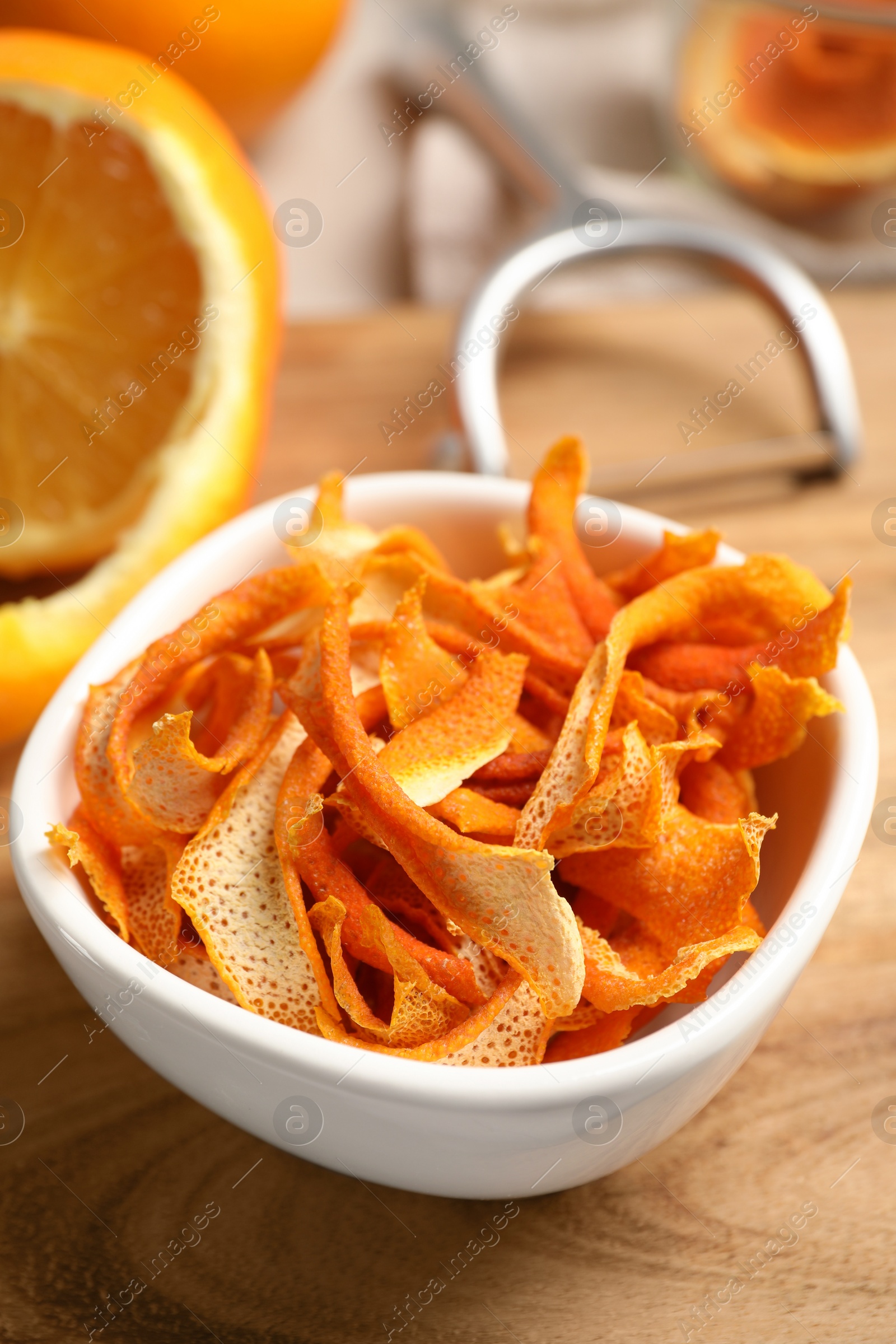 Photo of Dry orange peels and fresh fruit on wooden board, closeup