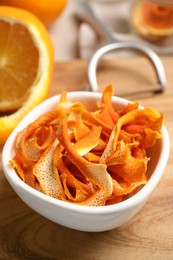 Photo of Dry orange peels and fresh fruit on wooden board, closeup