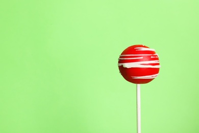 Bright delicious cake pop on color background. Space for text