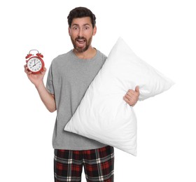 Photo of Emotional overslept man with alarm clock and pillow on white background