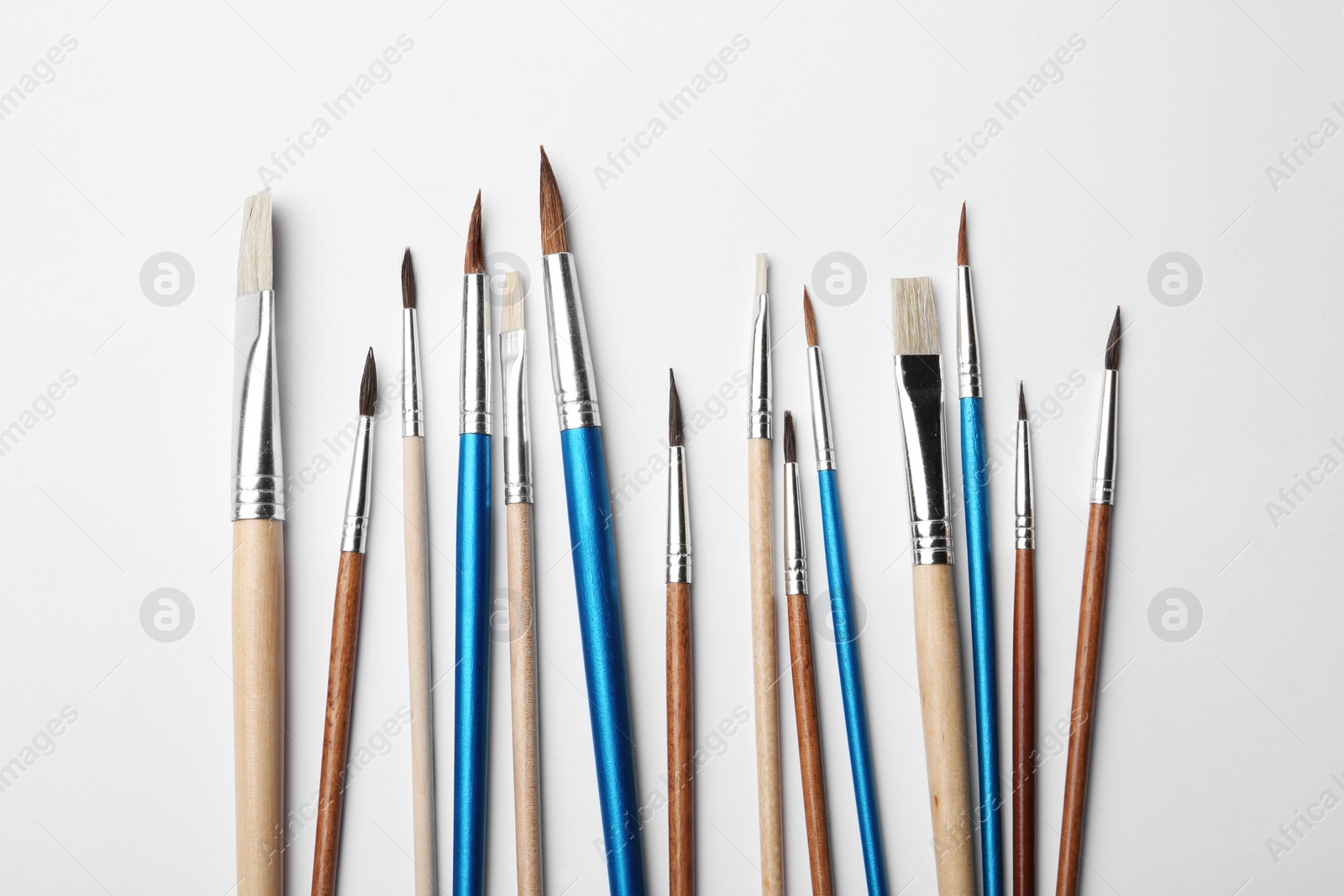 Photo of Different paint brushes on white background, top view