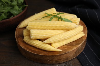 Photo of Tasty fresh yellow baby corns on wooden table