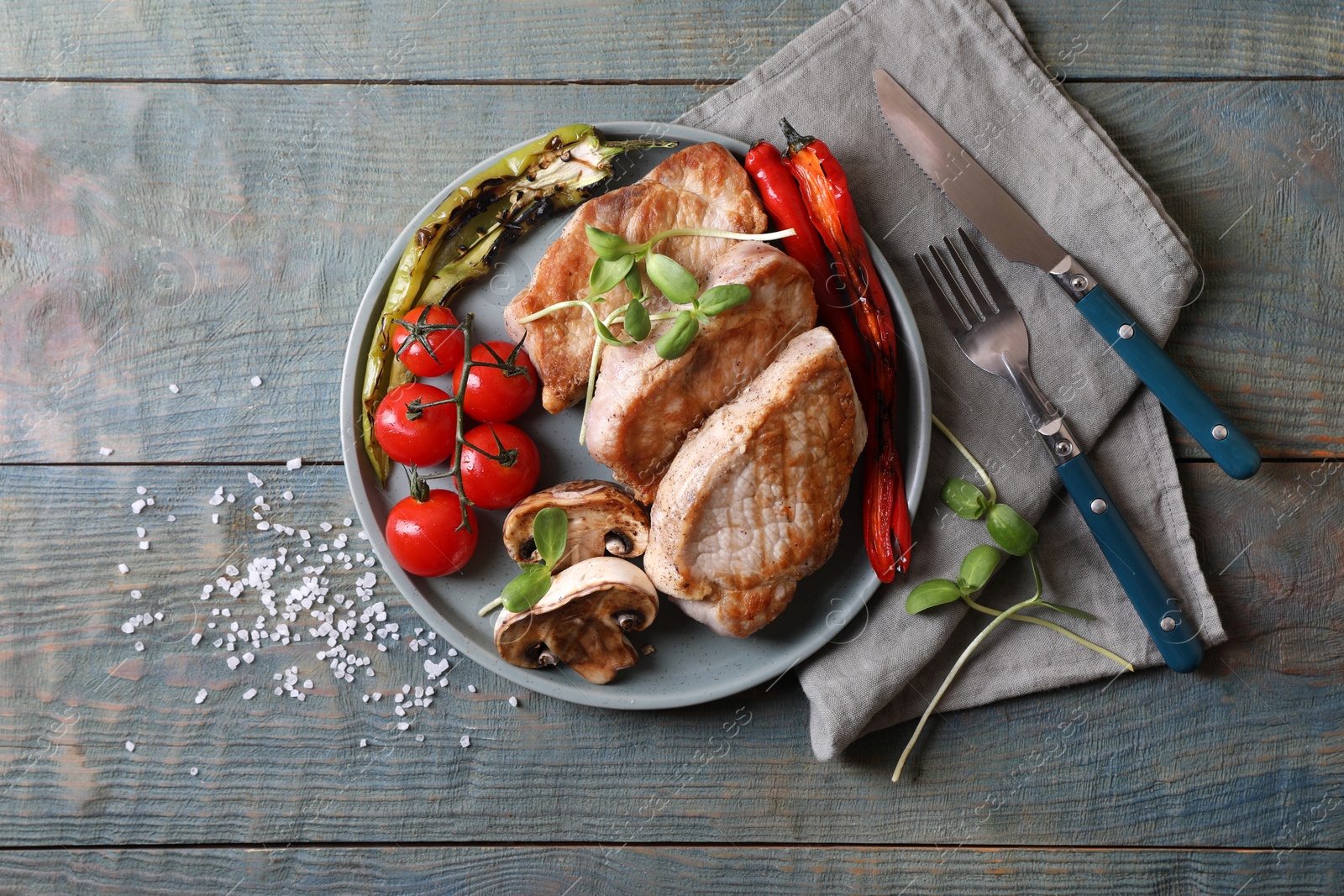 Photo of Delicious grilled meat and vegetables served on wooden table, flat lay