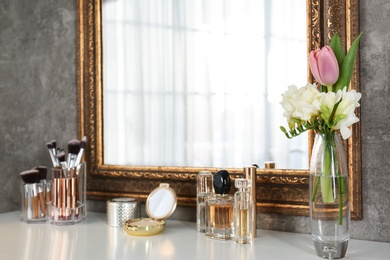 Photo of Dressing table with set of luxury cosmetic products. Interior element