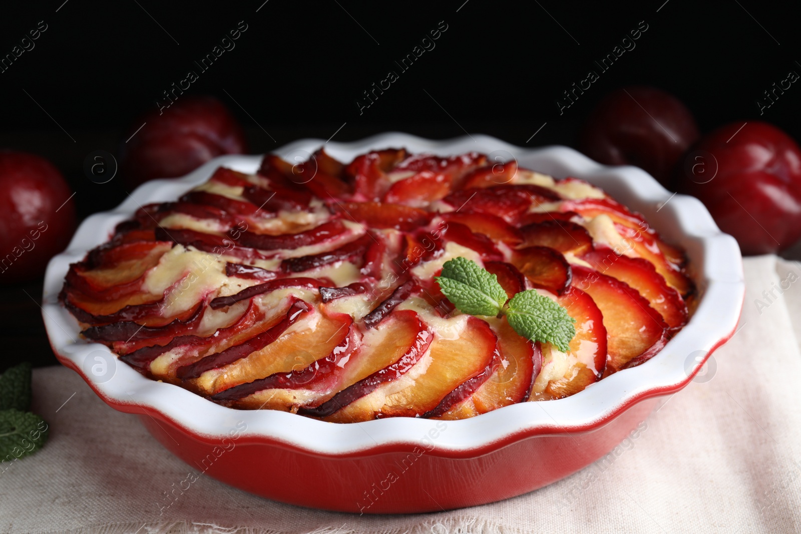 Photo of Delicious cake with plums in baking dish, closeup