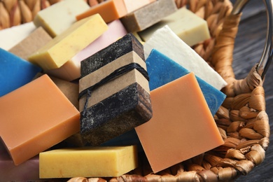 Many different handmade soap bars in wicker basket, closeup