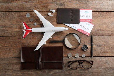 Flat lay composition with toy airplane and travel items on wooden background