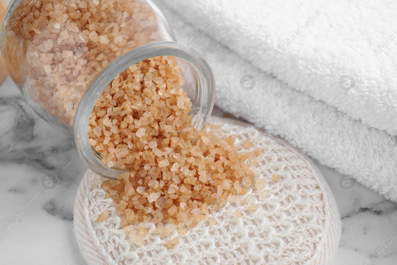 Photo of Jar with salt for spa scrubbing procedure on white marble table