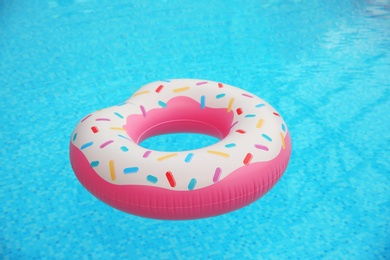 Inflatable ring floating on water in swimming pool