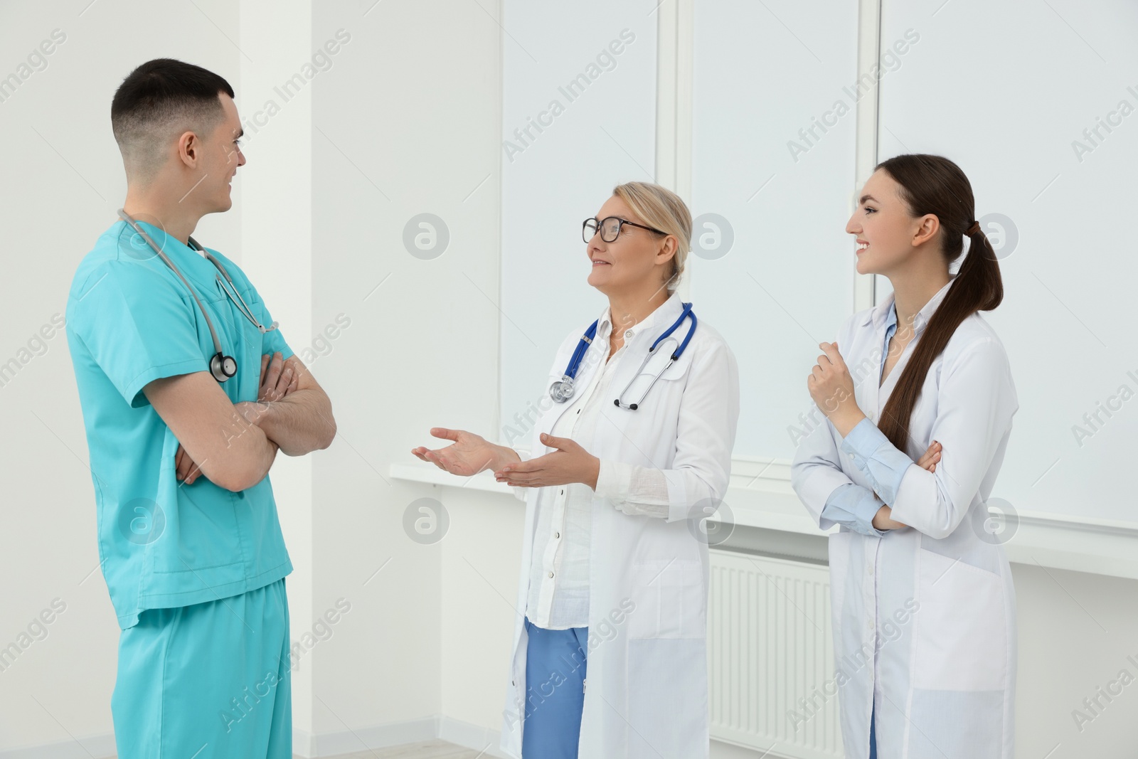 Photo of Medical doctors in uniforms having discussion in clinic