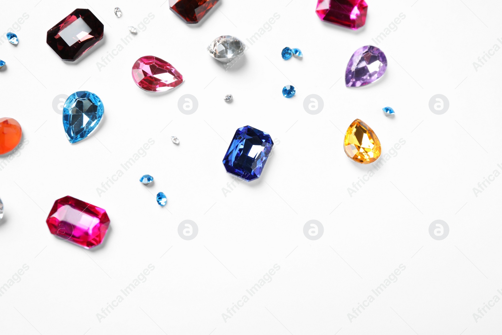 Photo of Different beautiful gemstones on white background, top view