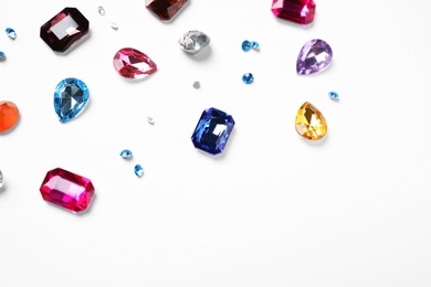 Photo of Different beautiful gemstones on white background, top view