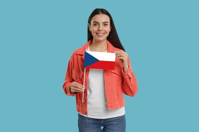 Image of Happy young woman with flag of Czech republic on light blue background