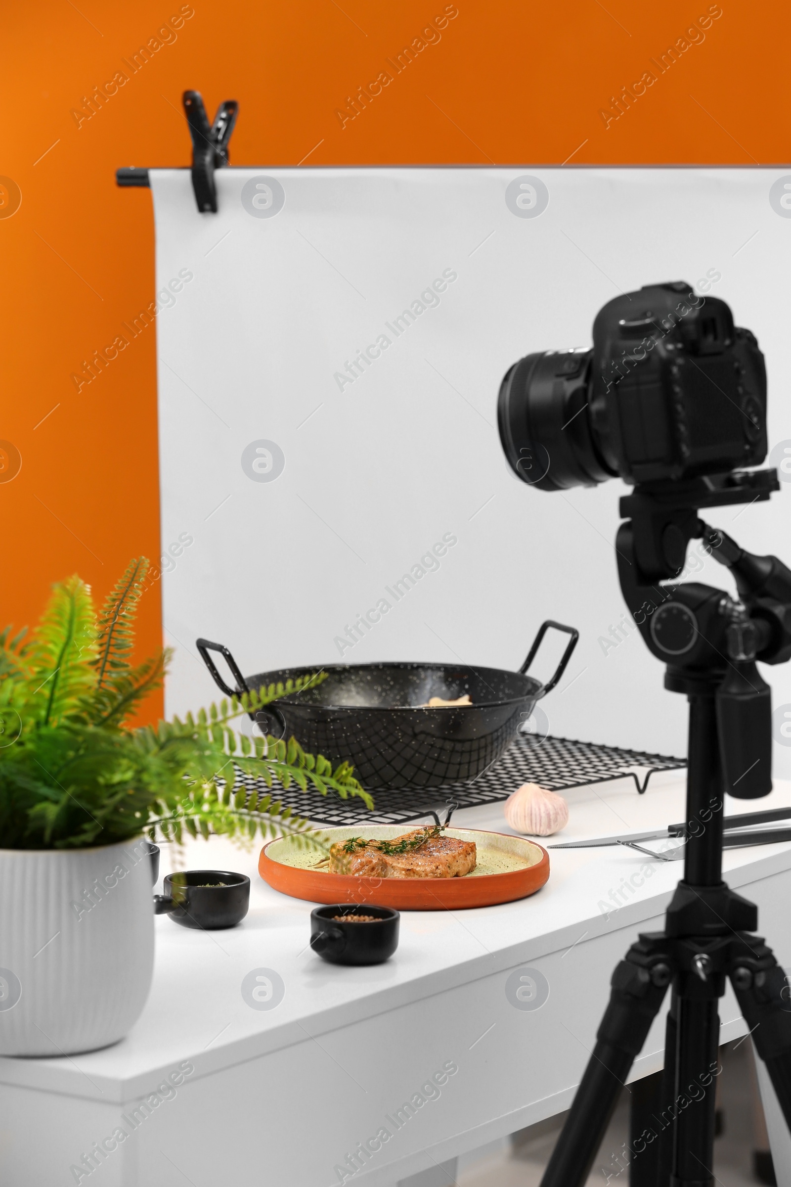 Photo of Professional camera on tripod and composition with delicious meat medallion in studio. Food photography