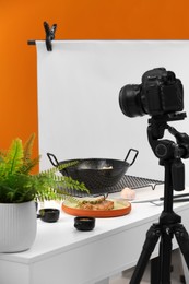 Photo of Professional camera on tripod and composition with delicious meat medallion in studio. Food photography