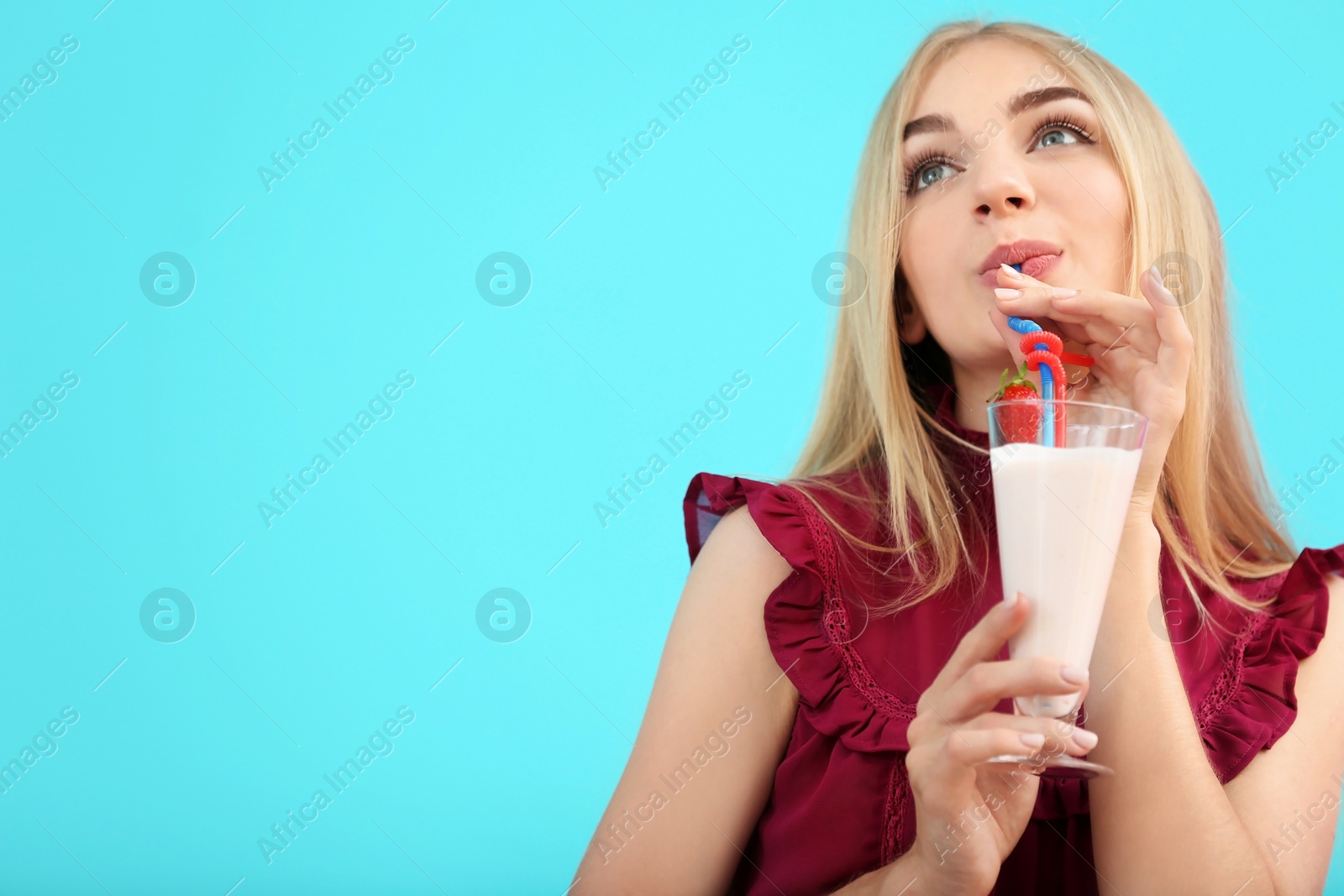 Photo of Young woman with glass of delicious milk shake on color background