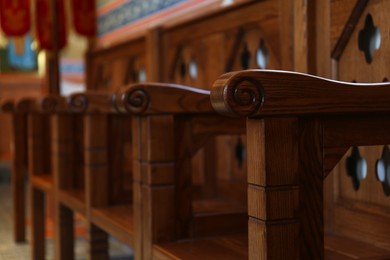 Empty wooden bench in church, closeup. Space for text