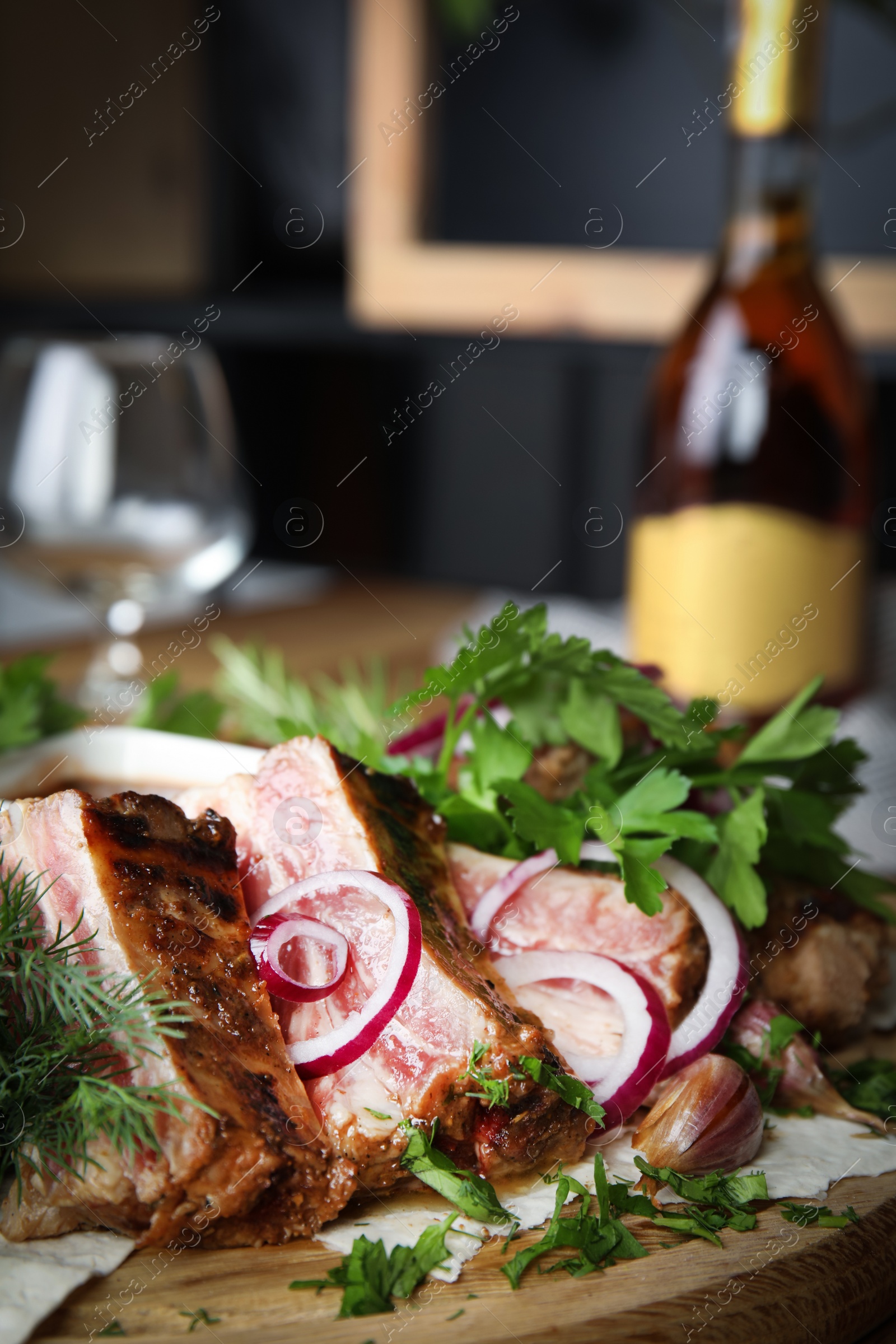 Photo of Delicious roasted meat with herbal on wooden board, closeup. Space for text