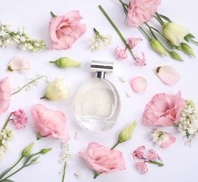 Photo of Luxury perfume and floral decor on white background, flat lay