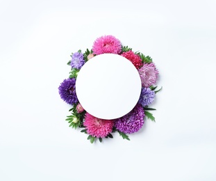 Photo of Beautiful aster flowers with sheet of paper on white background, top view. Space for text