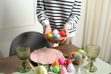 Photo of Woman setting table for festive Easter dinner at home, closeup